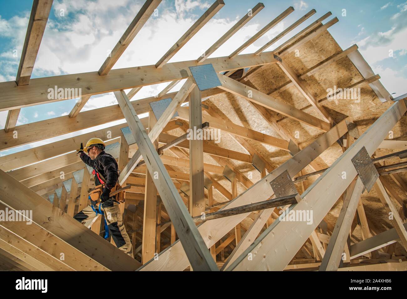 New Wooden Residential Building Developing. Caucasian Contractor Worker and the Wood Frame Installation. Construction Industry. Stock Photo