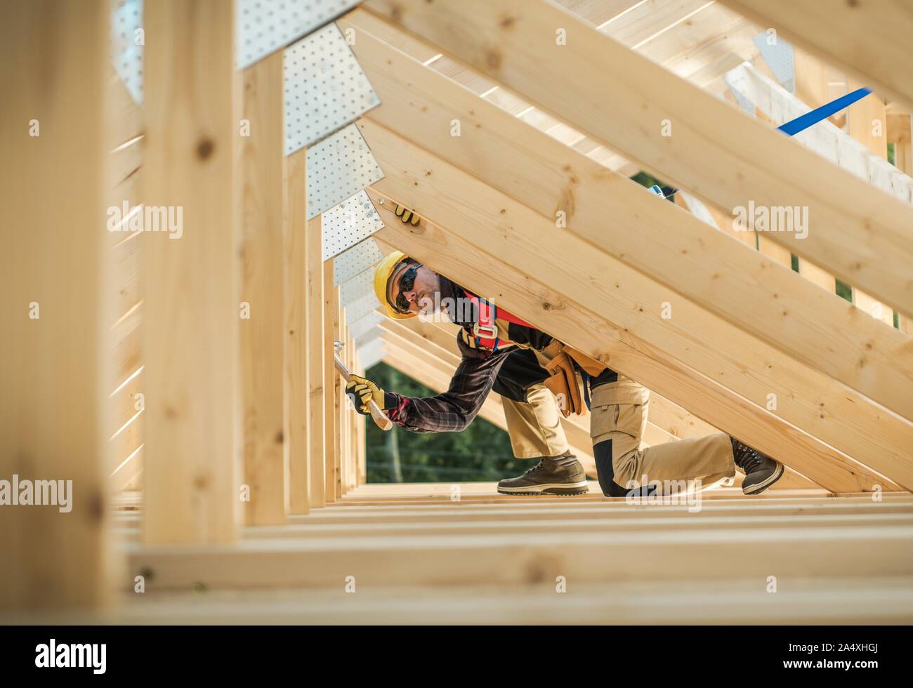 Caucasian Contractor Working with Wooden House Frame in the Attic Section. Stock Photo