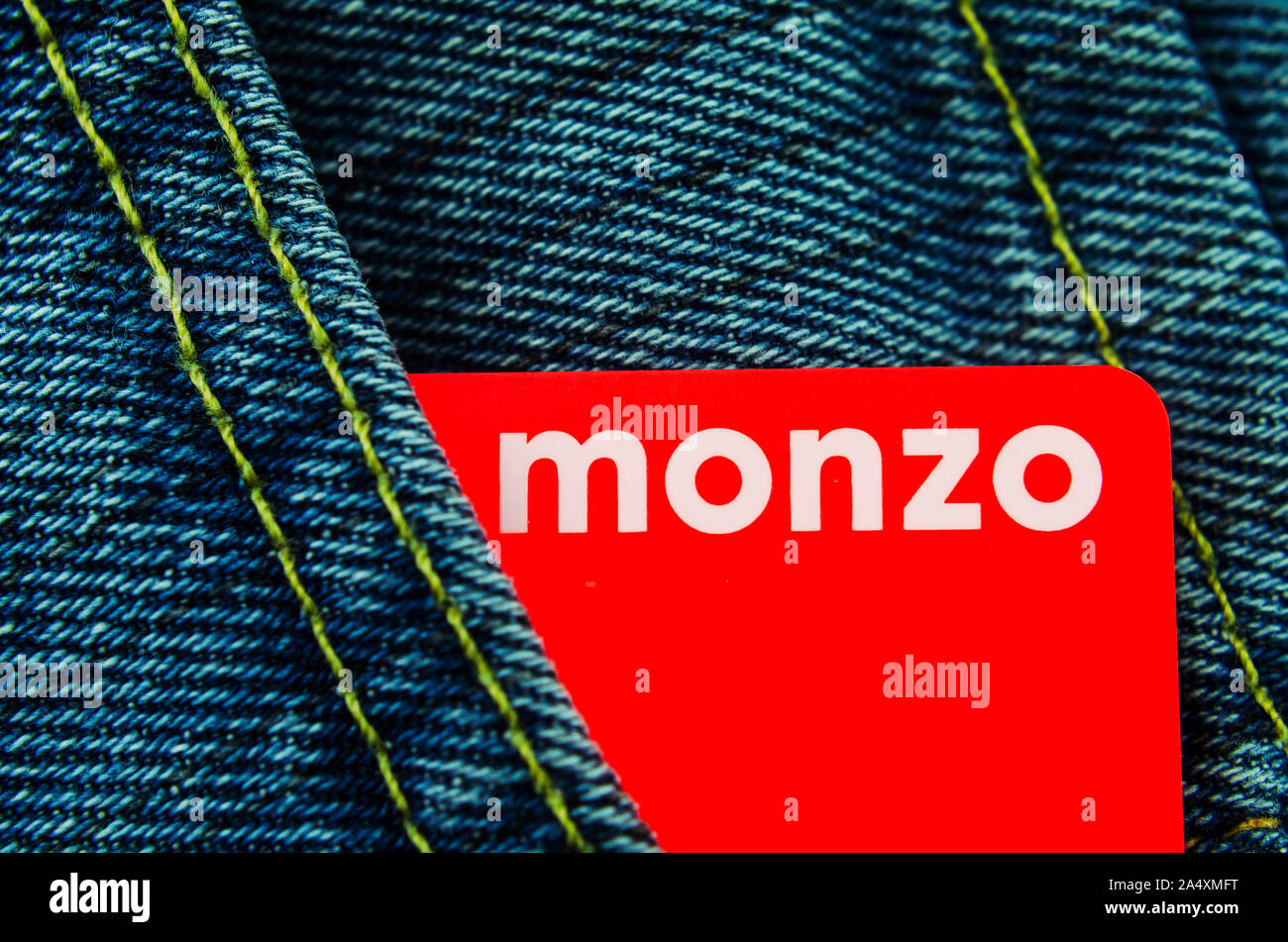 Monzo bank card in the jeans pocket. Macro photo. Stock Photo