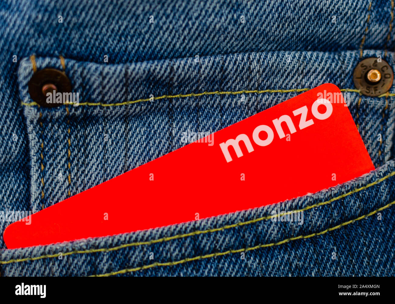 Monzo bank card sticking from the jeans pocket. Close up photo. Stock Photo