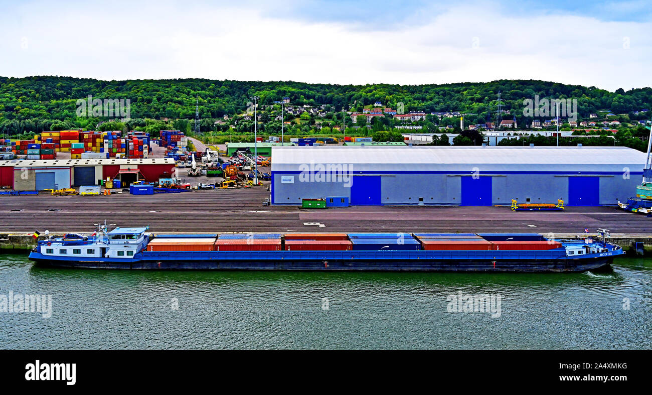 River Seine La Havre area Rouen August 14 2019  Container loading site with the barge Arc En Ciel alongside waiting at the dockside Stock Photo