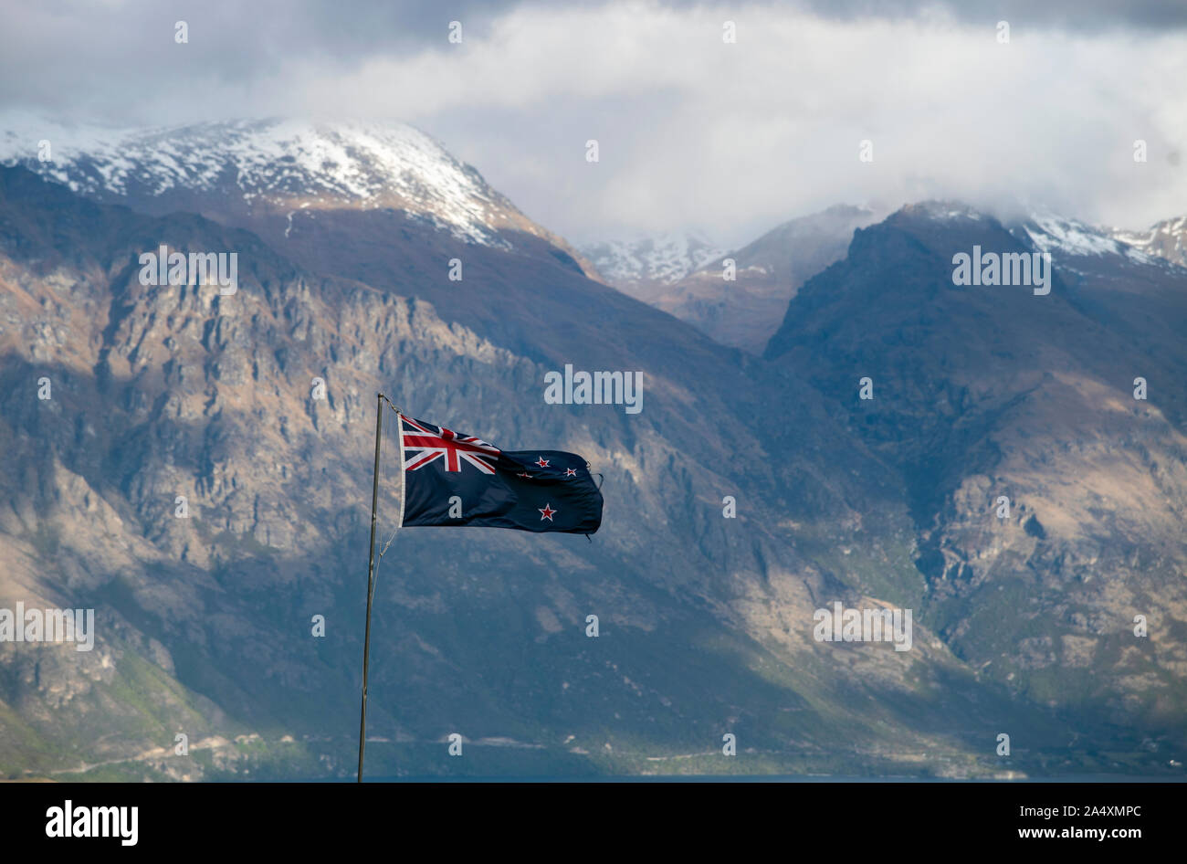 New Zealand flag flying in front of snowy mountains Stock Photo