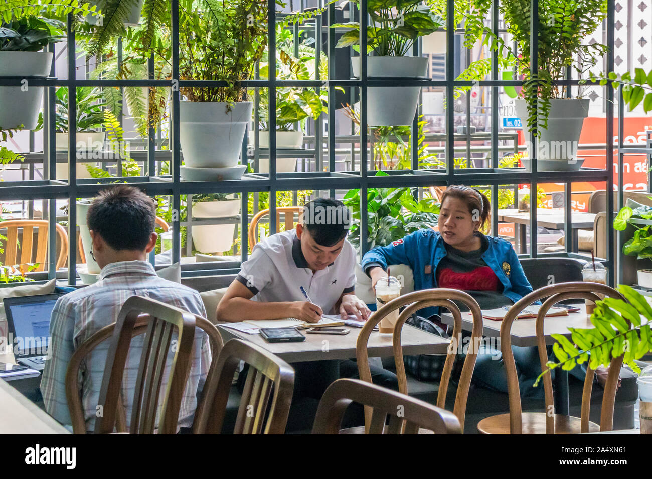 Bangkok, Thailand - January 30th 2019: Students studying in a coffee shop. There are many coffee shops in the city. Stock Photo