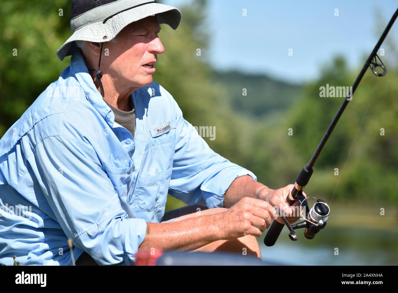 Unemotional Male Fisherman Outdoorsman With Rod And Reel Fishing Stock  Photo - Alamy