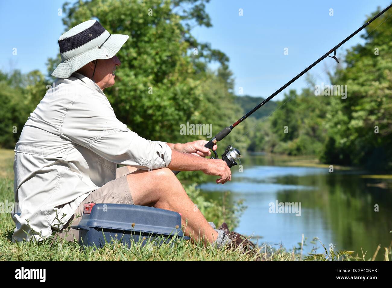 Old Retiree Outdoorsman Resting With Fishing Rod Fishing Stock Photo