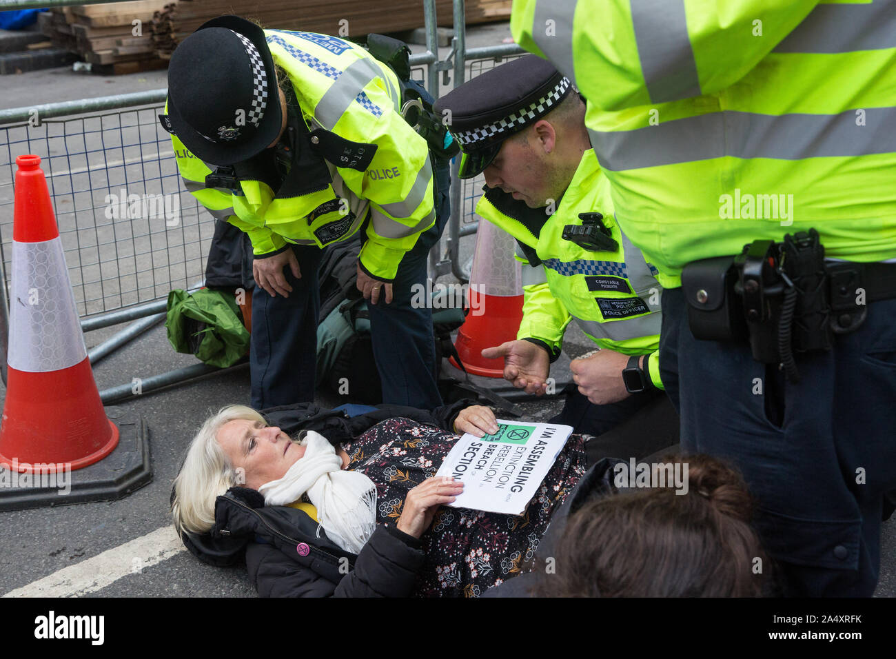 London, UK. 16 October, 2019. Police officers arrest a climate activist from Extinction Rebellion who had defied the Metropolitan Police prohibition on Extinction Rebellion Autumn Uprising protests throughout London under Section 14 of the Public Order Act 1986 by sitting in the road in Whitehall. Credit: Mark Kerrison/Alamy Live News Stock Photo