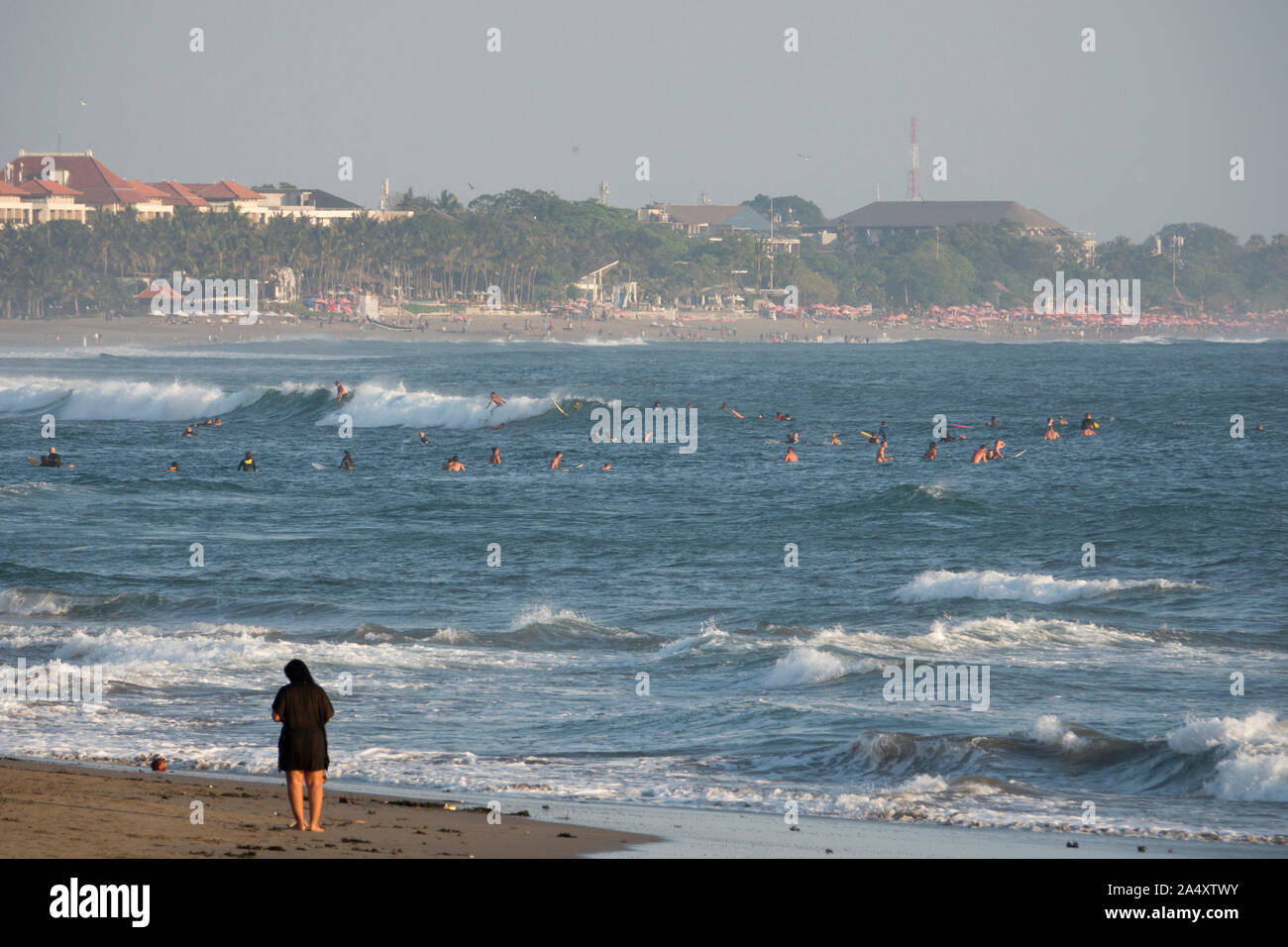 Surfers surfing waves at Seminyak in Bali Stock Photo Alamy