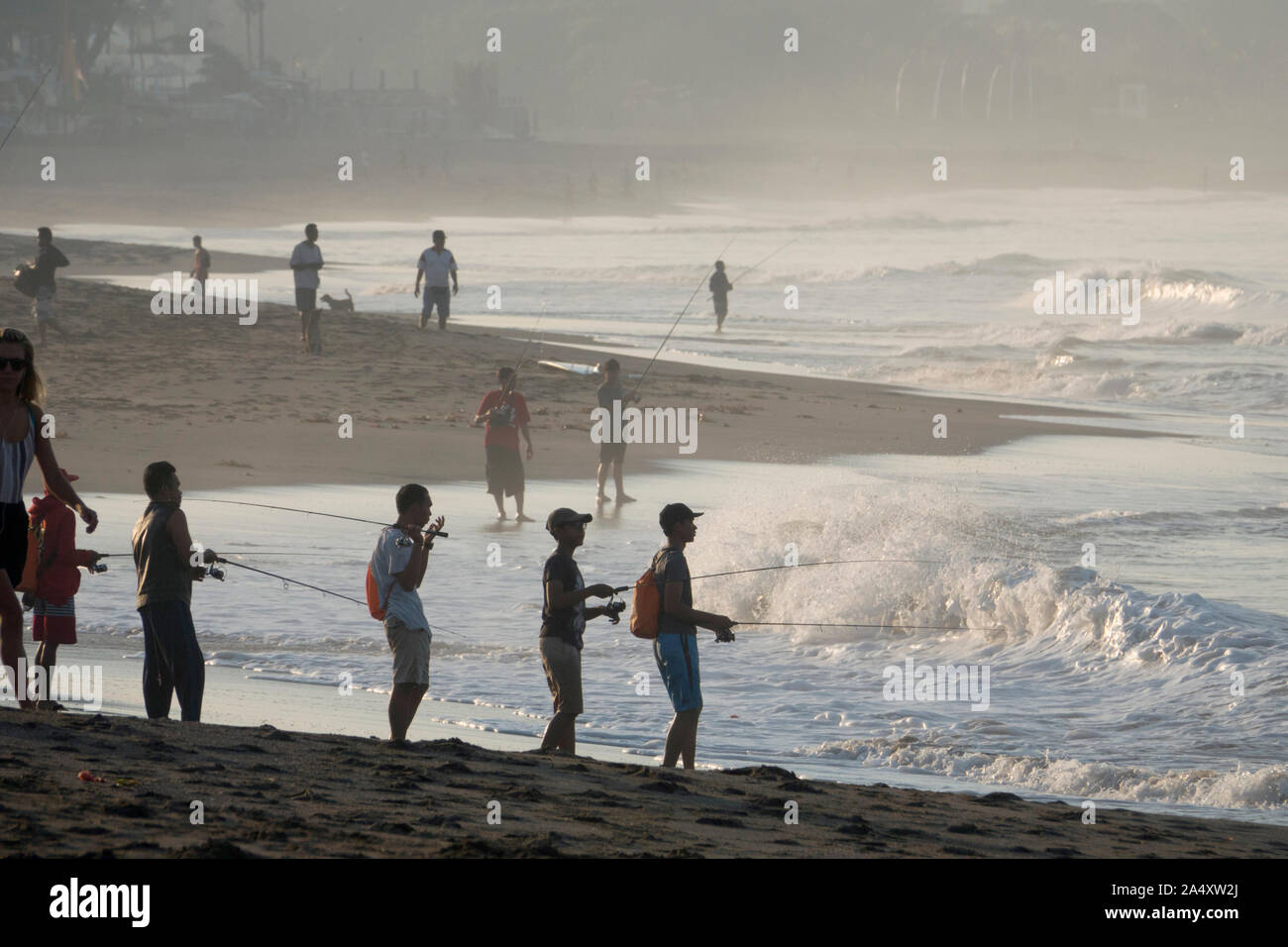 Balinese fishermen surfcasting at Canggu beach in Bali Stock Photo