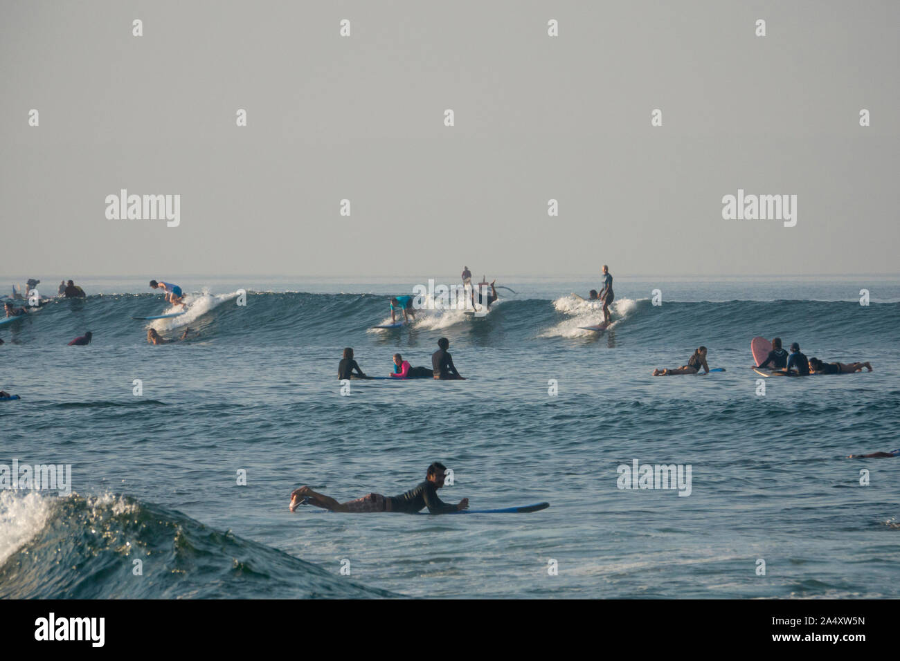 Men and women surfing at Canggu beach in Bali, Indonesia Stock Photo