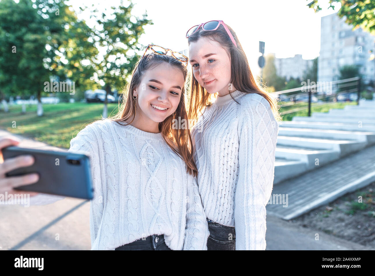 Schoolgirls teenagers girls, 2 girlfriends take pictures themselves on  phone, happy smiling have fun, record video, video call, have fun in city  in Stock Photo - Alamy