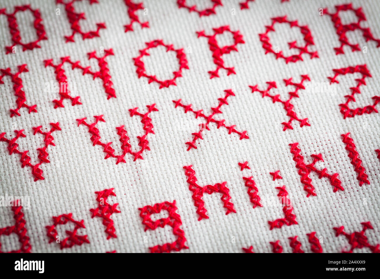 Red Alphabet Cross Stitch Close Up with Upper Case and Lower Case Letters. Stock Photo