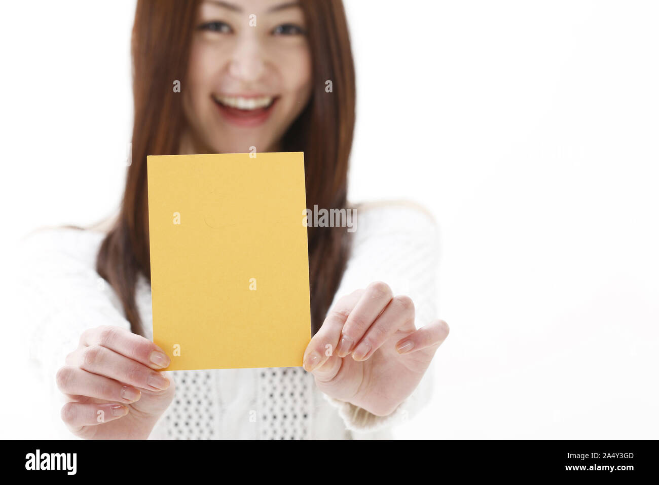 a smiling young woman showing yellow card Stock Photo