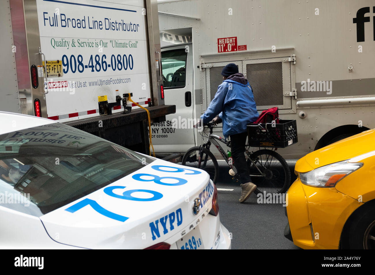 Bike rider in traffic, Manhattan, New York, United States of America Stock Photo