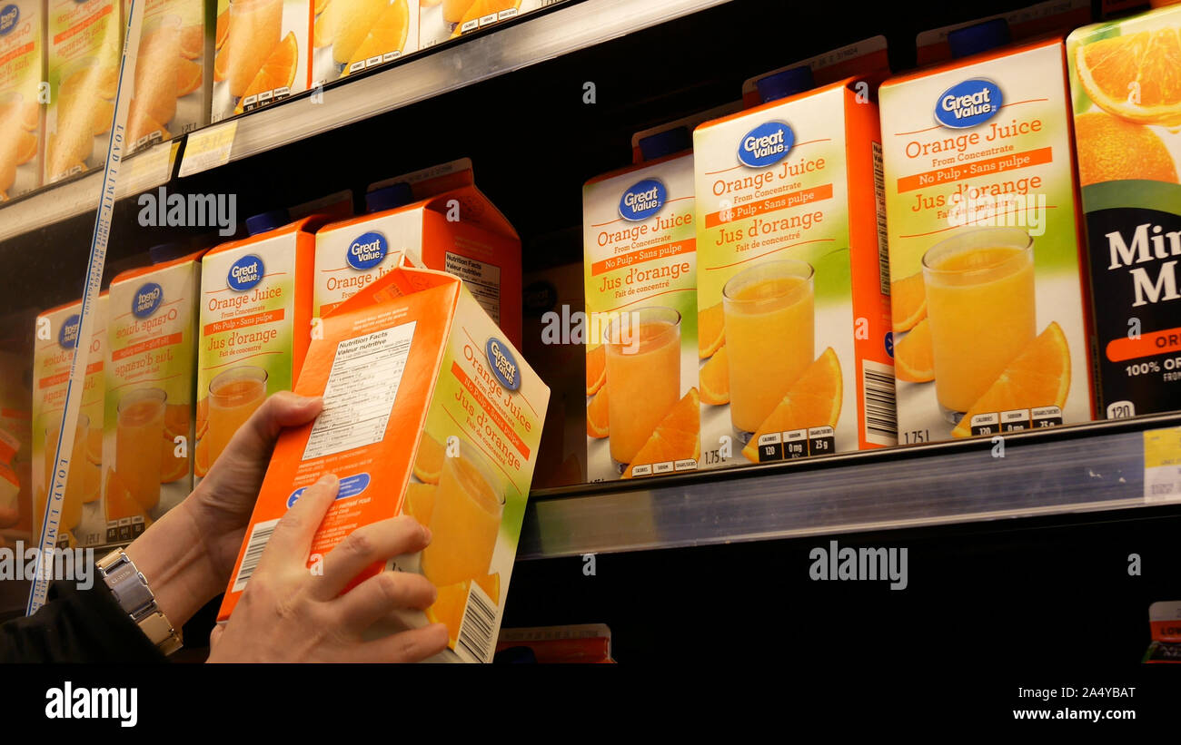 Motion of woman buying great value orange juice inside Walmart store Stock Photo