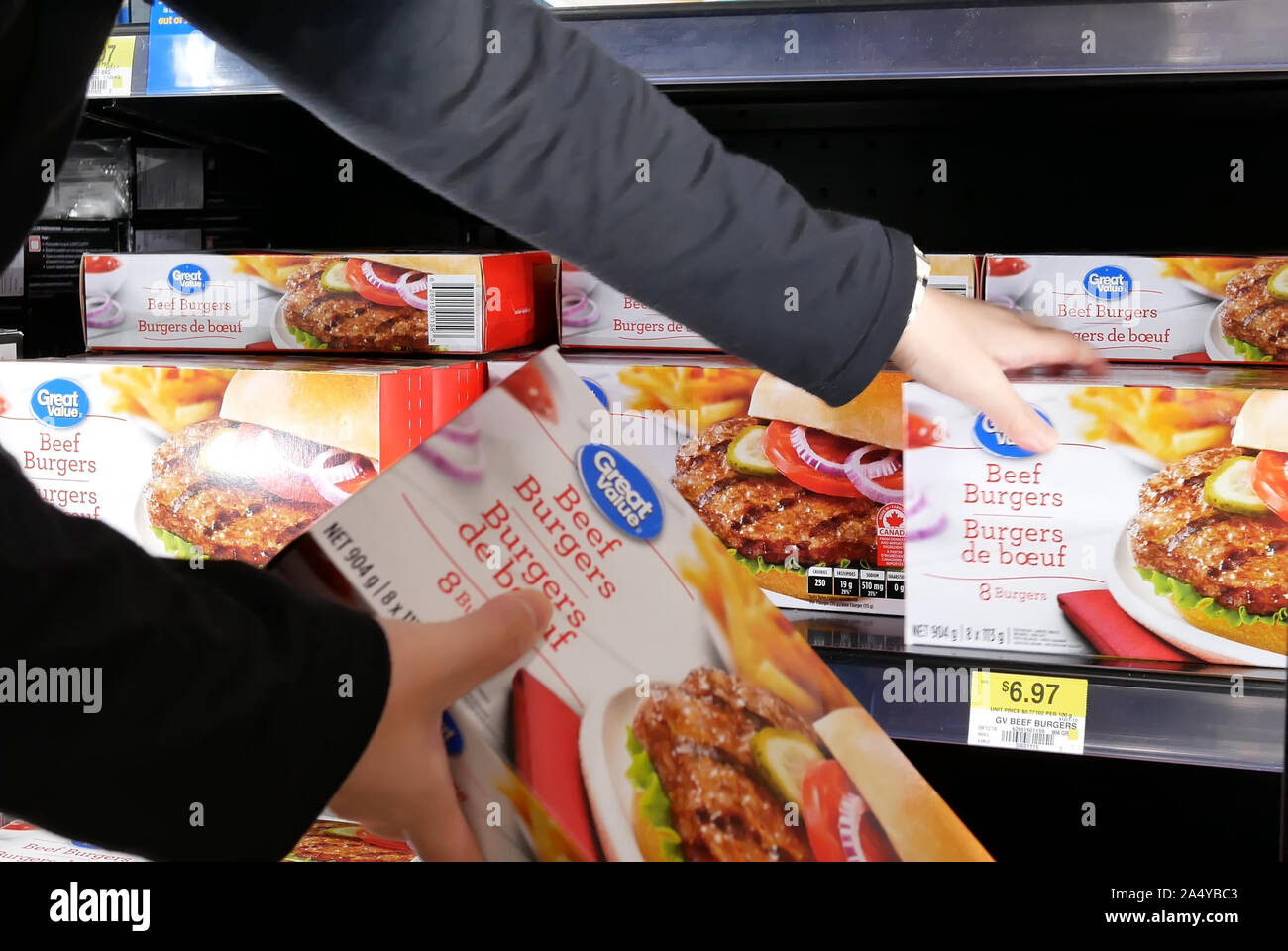 Motion of woman buying great value beef burgers inside Walmart store Stock Photo
