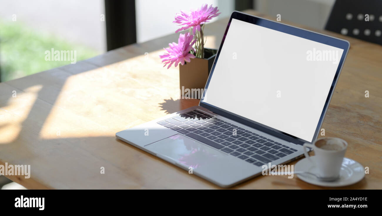Open blank screen laptop computer in comfortable workspace next to the ...