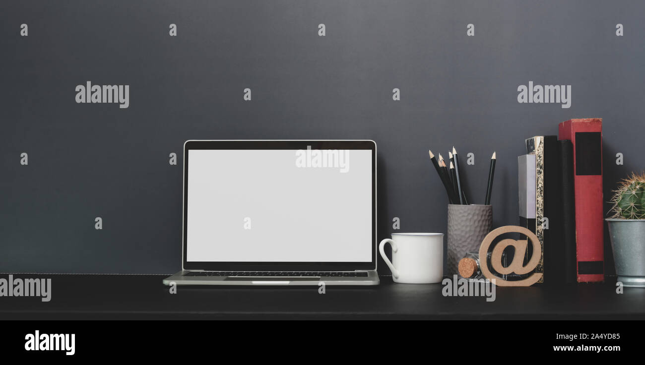 Open blank screen laptop computer in modern workspace with decorations ...