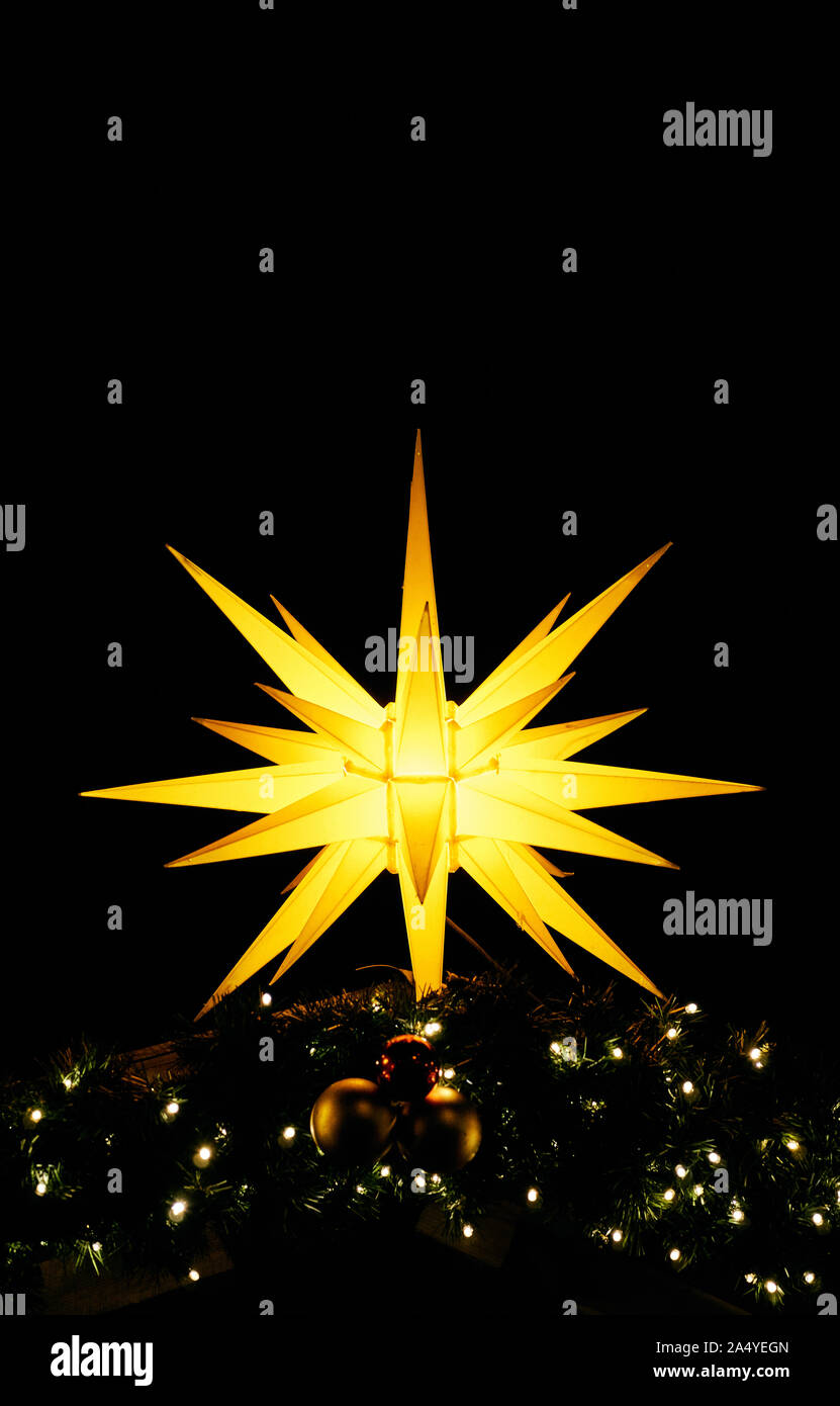 Shiny christmas star as a vertical background. Christmas decoration in the night. Stock Photo