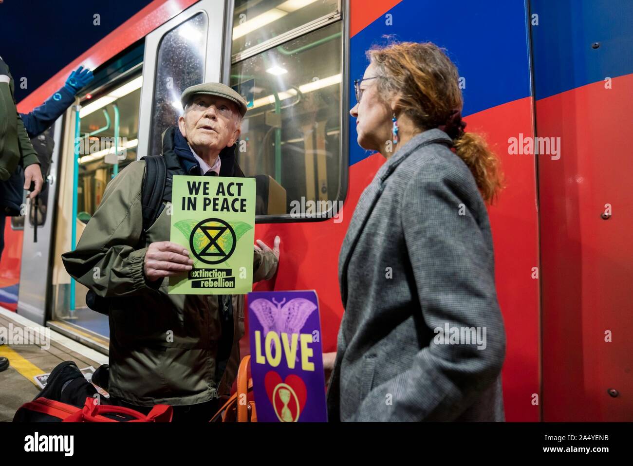 London, UK. 17th Oct, 2019. Members of Christian Climate Action Phil Kingston (83, retired probation officer and lecturer from Bristol) glued and Ruth Jarman (56, mother of 3 from Hampshire) kneeling; at Shadwell station during the Extinction Rebellion protests in central London, UK. Credit: Vladimir Morozov/Alamy Live News Stock Photo