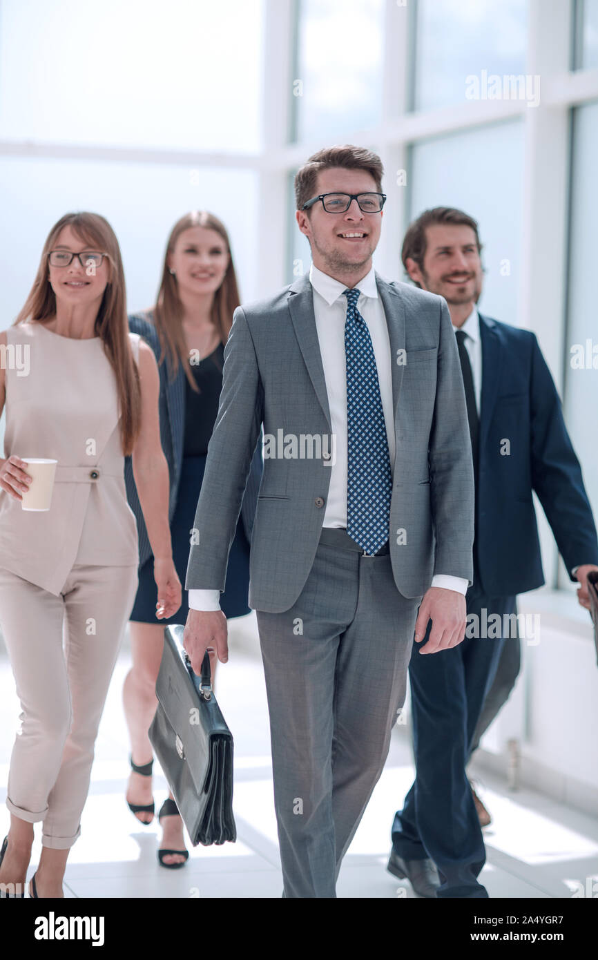 business people confidently walking in a modern office building Stock
