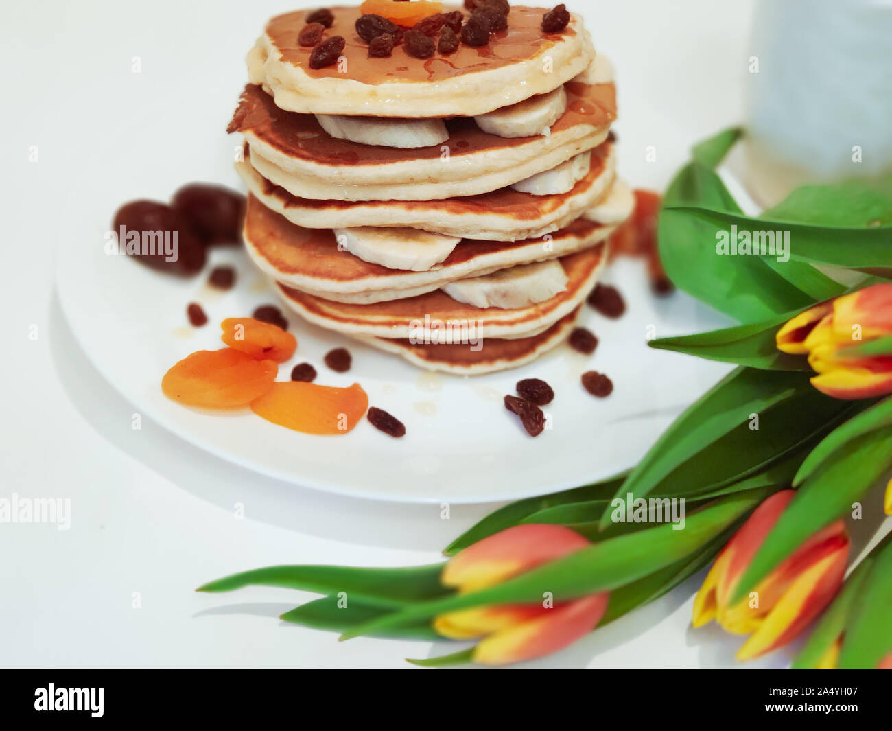 Stack of Pancakes on the Table with Tulips Stock Photo