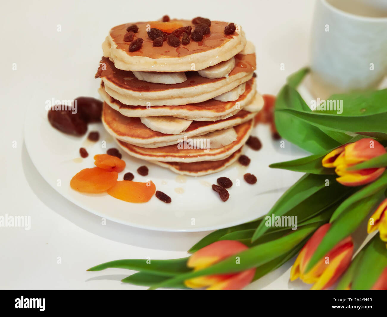Stack of Pancakes on the Table with Tulips Stock Photo