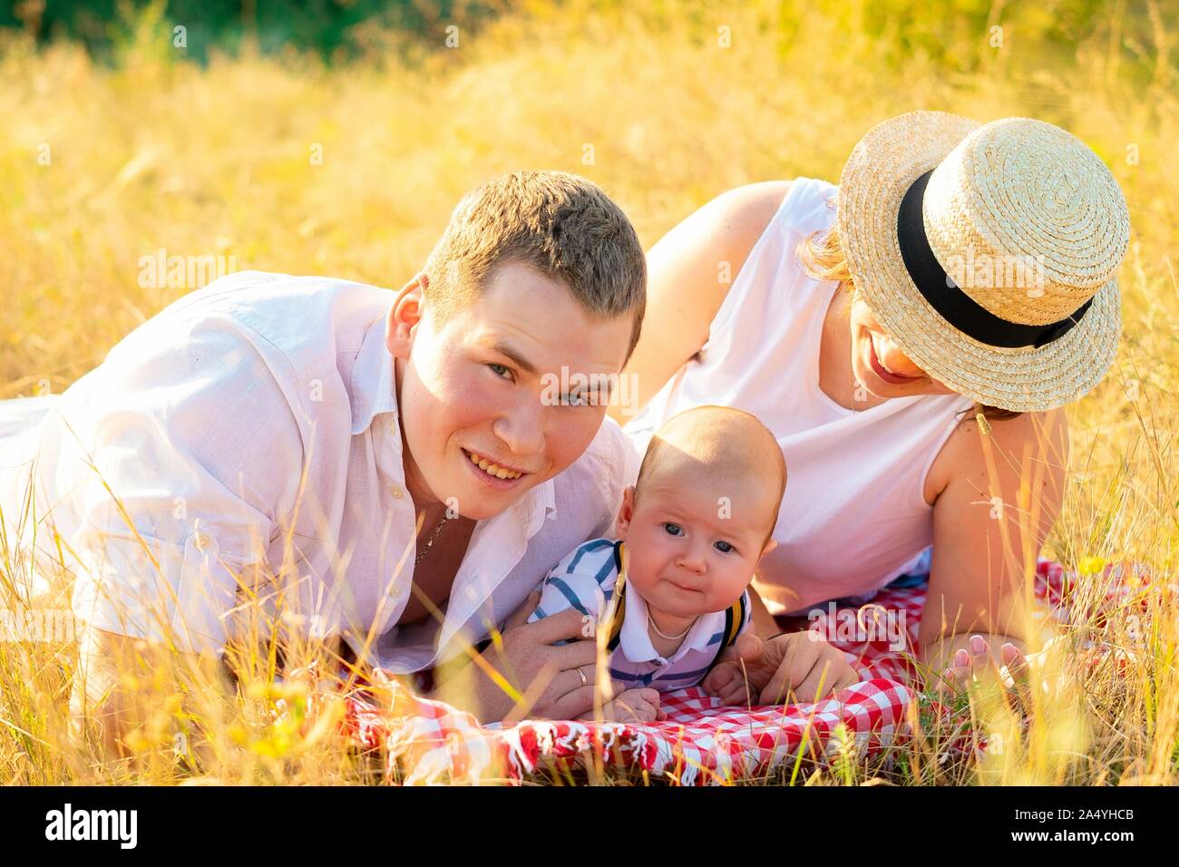 Family with baby at summer sunset. Stock Photo