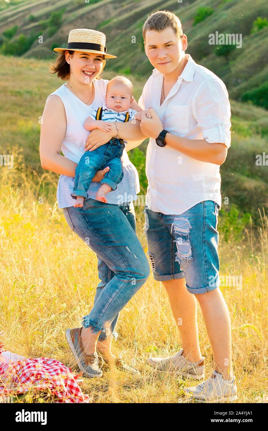 Happy family with little baby spending time together at sunset Stock Photo