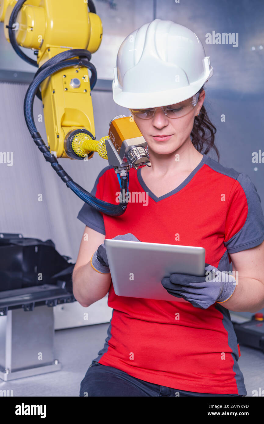 A young female technician while machine constructing in a manufacturing plant Stock Photo