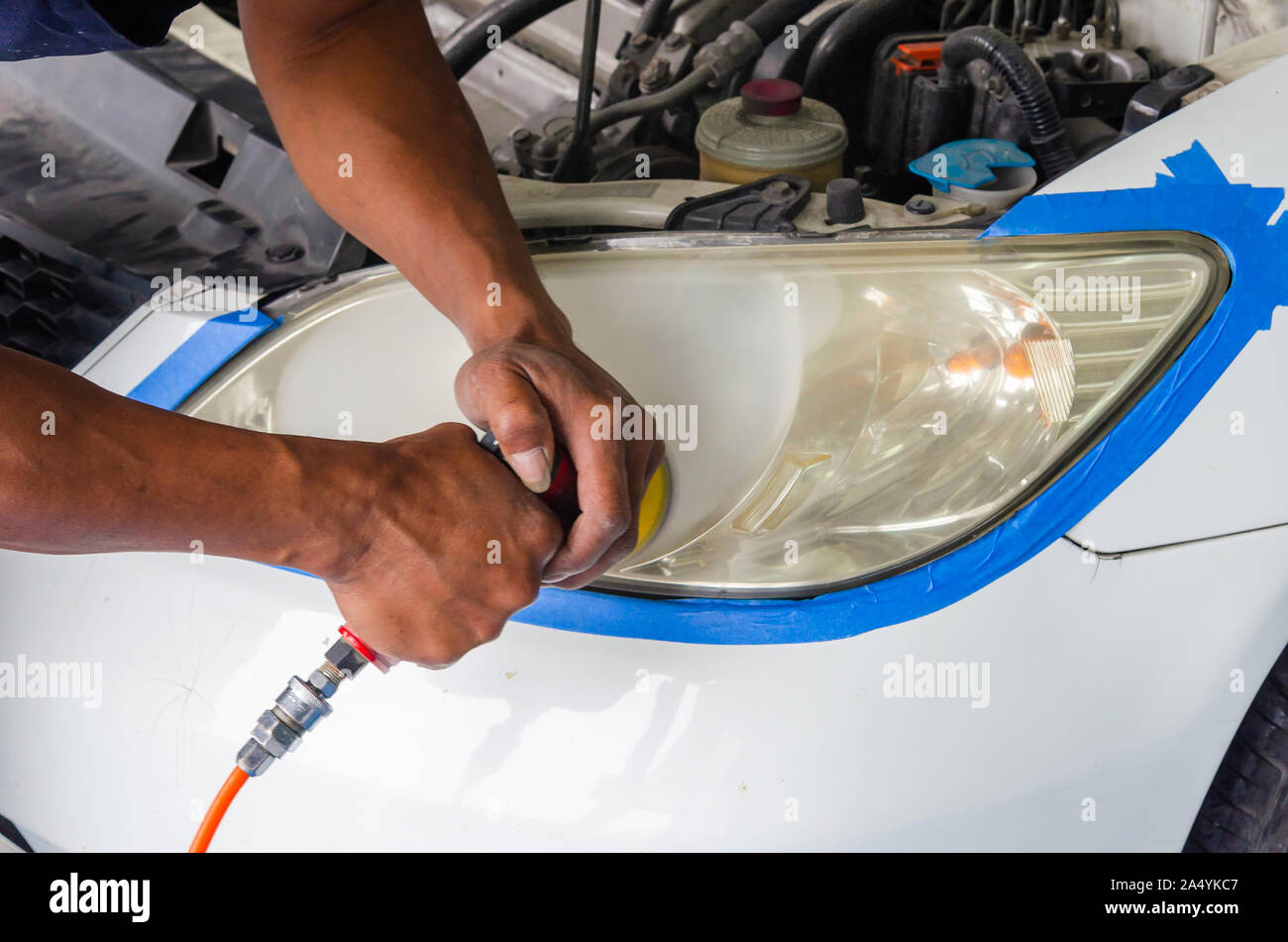 mechanic's hand is polishing the car's headlight. Stock Photo