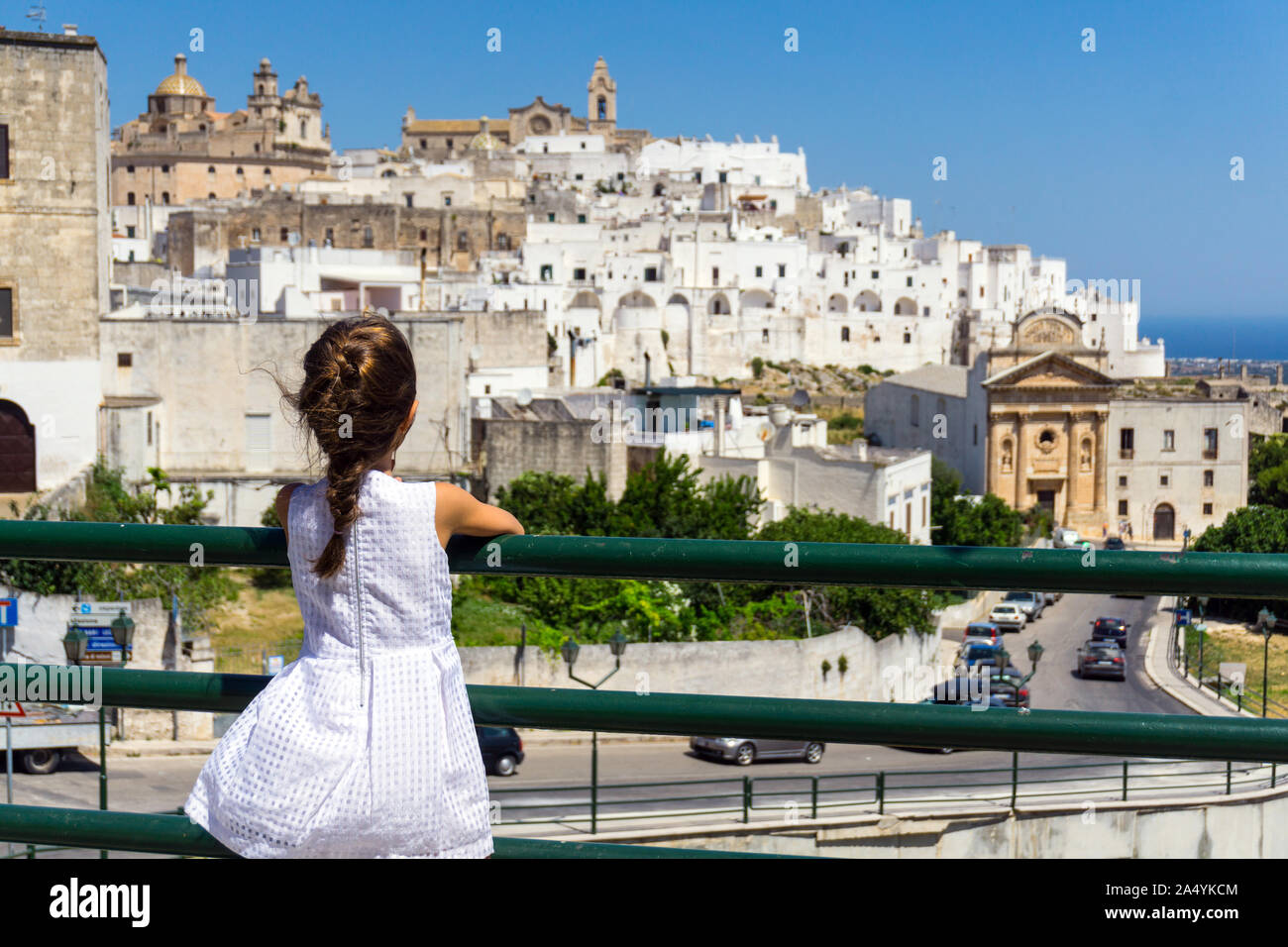 Italy, Apulia, Ostuni, little girl looking old town cityscape Stock Photo