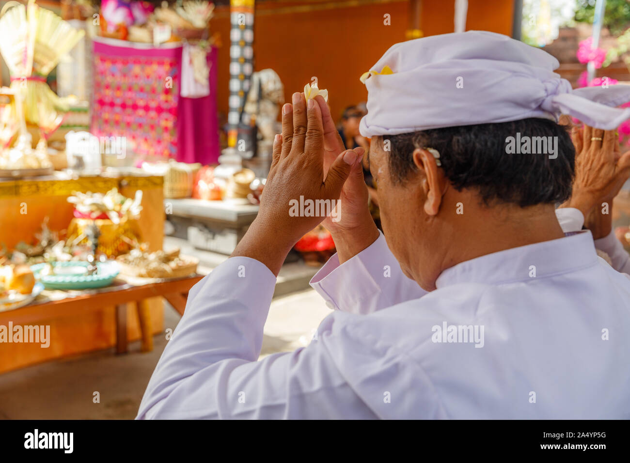 Balinese Hindu praying during religious ceremony in family temple (Sanggah). Bali, Indonesia. Stock Photo