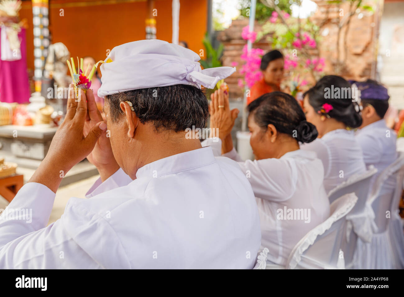 Balinese Hindu praying during religious ceremony in family temple (Sanggah). Bali, Indonesia. Stock Photo