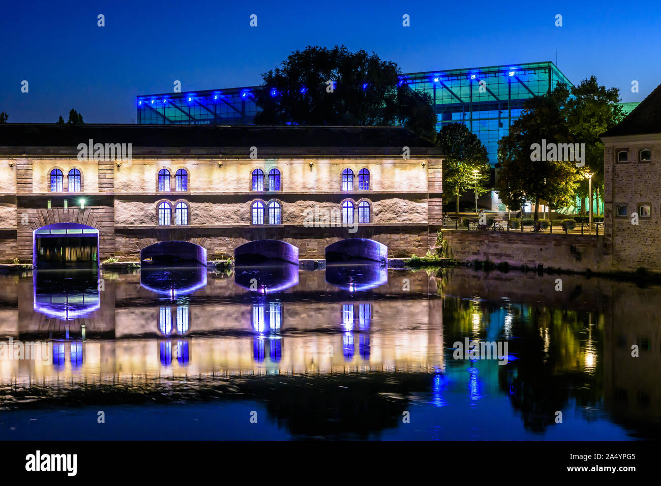 The Vauban Dam at nightfall in Strasbourg, France,  a defensive work on the river Ill and the Museum of Modern and Contemporary Arts in the background Stock Photo