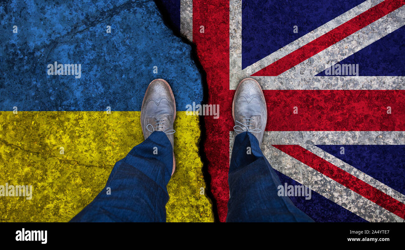 Business man stands on cracked flag of UK and Ukraine. Political concept Stock Photo