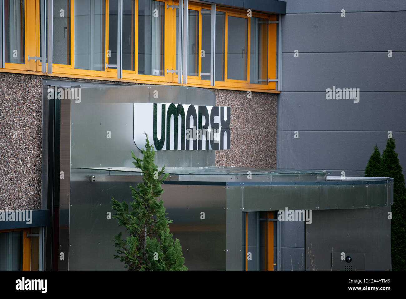 17 October 2019, North Rhine-Westphalia, Arnsberg: The company logo hangs on the outer facade of the weapons manufacturer Umarex. Because for years he is said to have smuggled pistol parts from a weapons manufacturer's factory, assembled and sold them, a 47-year-old man is now on trial in Arnsberg, Sauerland. Since 2015, the long-time employee of the Arnsberg-based sporting weapons manufacturer Umarex has been reported to have repeatedly stolen design drawings and weapon parts from his former employer and assembled them into functional weapons at home. Five other men - some from the rocker sce Stock Photo