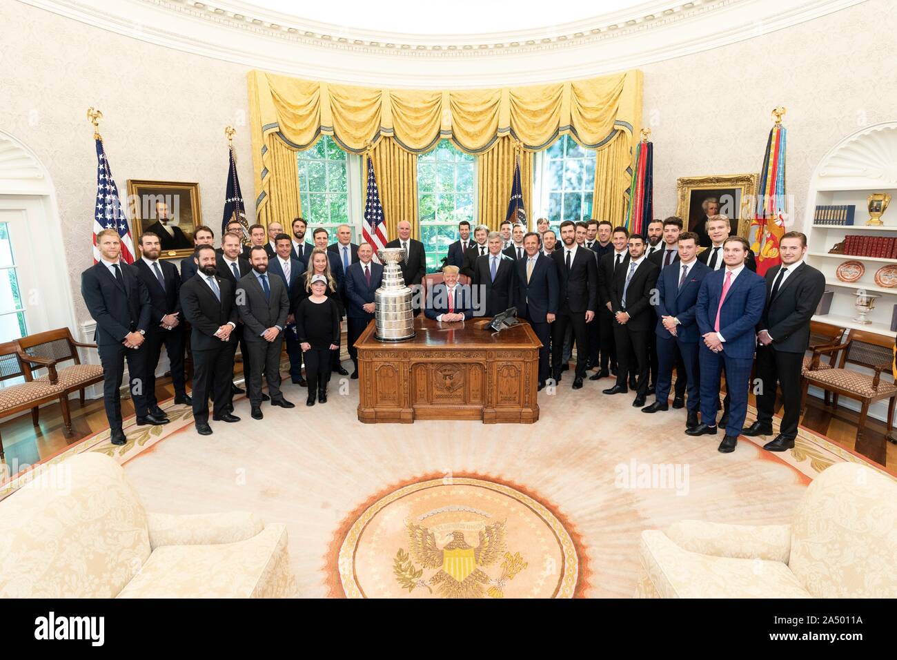 U.S President Donald Trump, center, poses with members of the 2019 Stanley Cup Championship professional ice hockey team, the St. Louis Blues, in the Oval Office of the White House October 15, 2019 in Washington, DC. Stock Photo