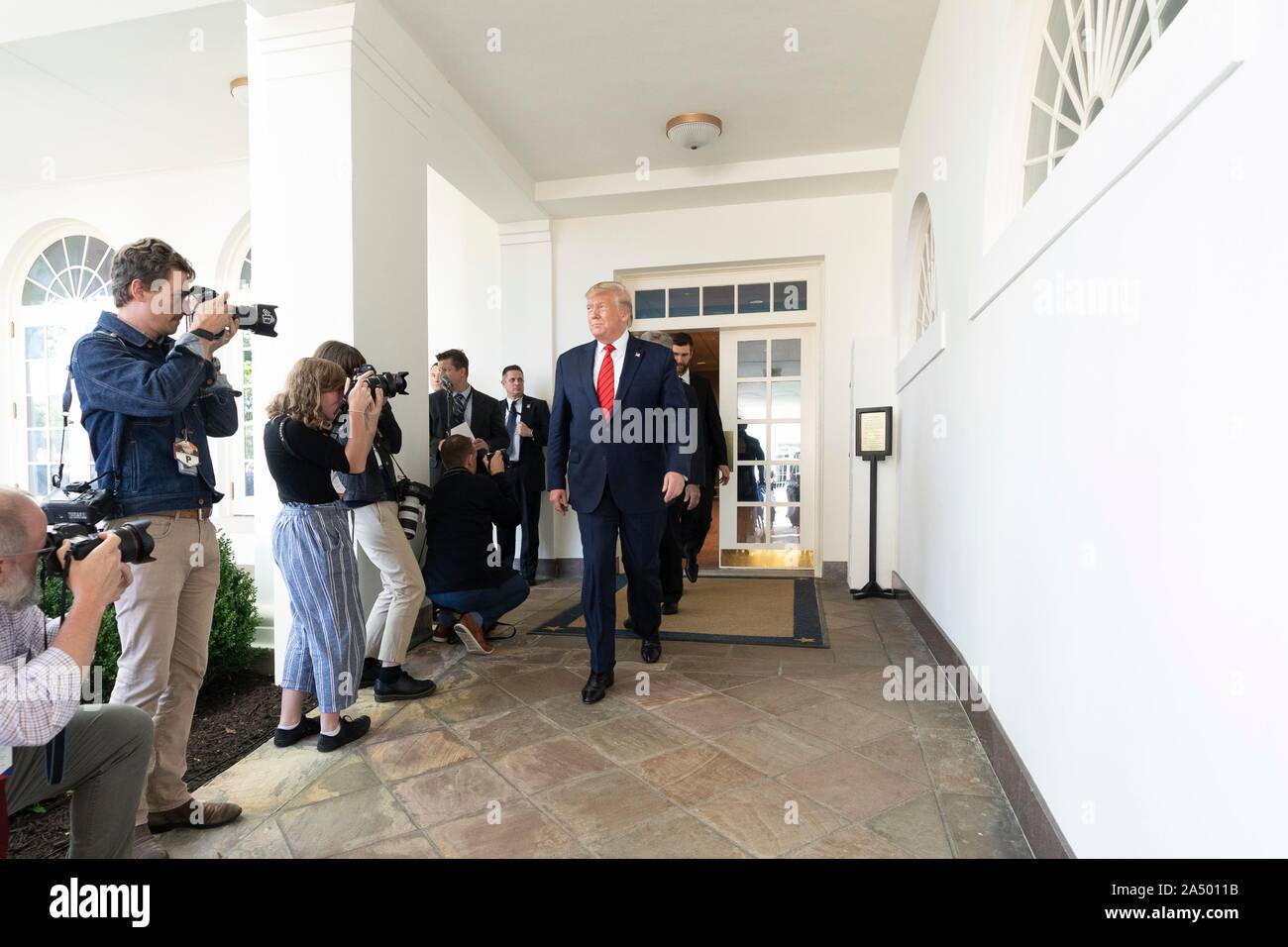 U.S President Donald Trump walks through the West Colonnade as he arrives for a celebration with the 2019 Stanley Cup Championship professional ice hockey team, the St. Louis Blues, in the Rose Garden of the White House October 15, 2019 in Washington, DC. Stock Photo