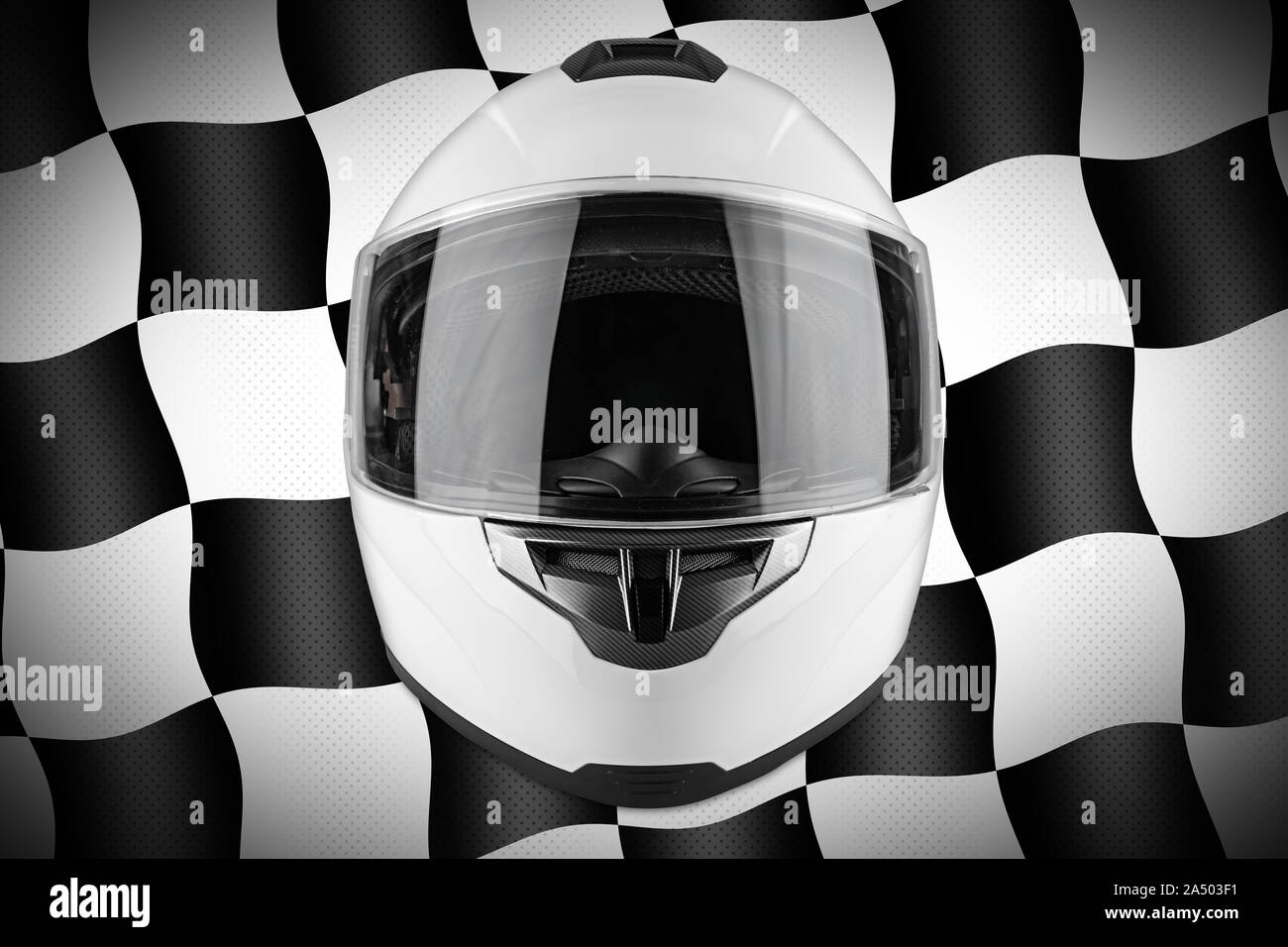 White motorcycle carbon integral crash helmet in front of motorsport black and chequered flag background. car kart racing transportation safety concep Stock Photo