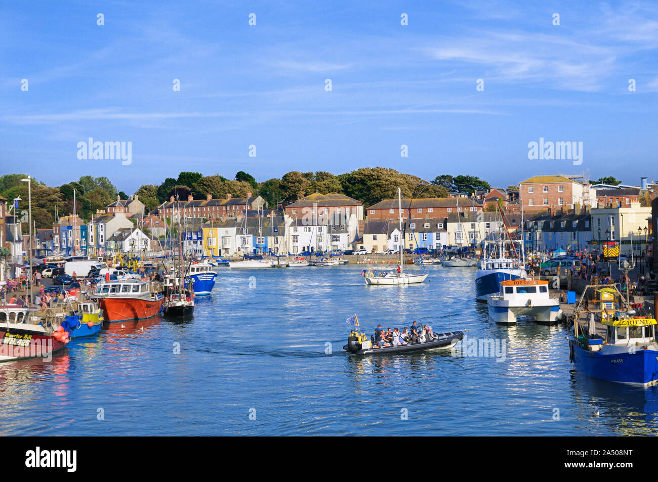 A view of the boats and cottages surrounding the Old Harbour in Weymouth on a summer's afternoon, Jurassic Coast, Dorset, England, UK Stock Photo
