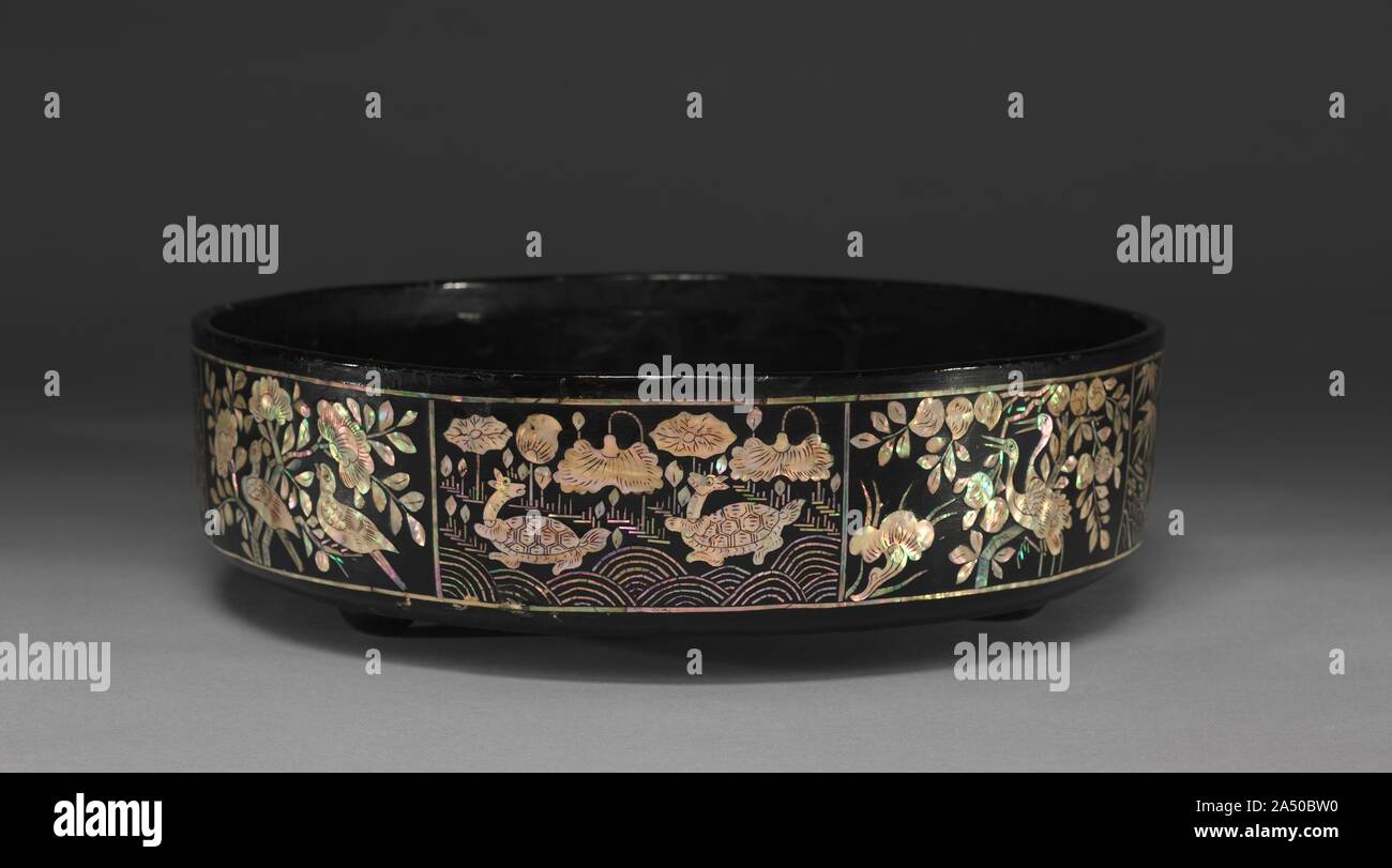 Box with Fish and Animal Design, 1800s. Many thin layers of lacquer were applied to the leather core of this round tray. The design was cut into the dry lacquer and then the mother-of-pearl was inserted. Stock Photo