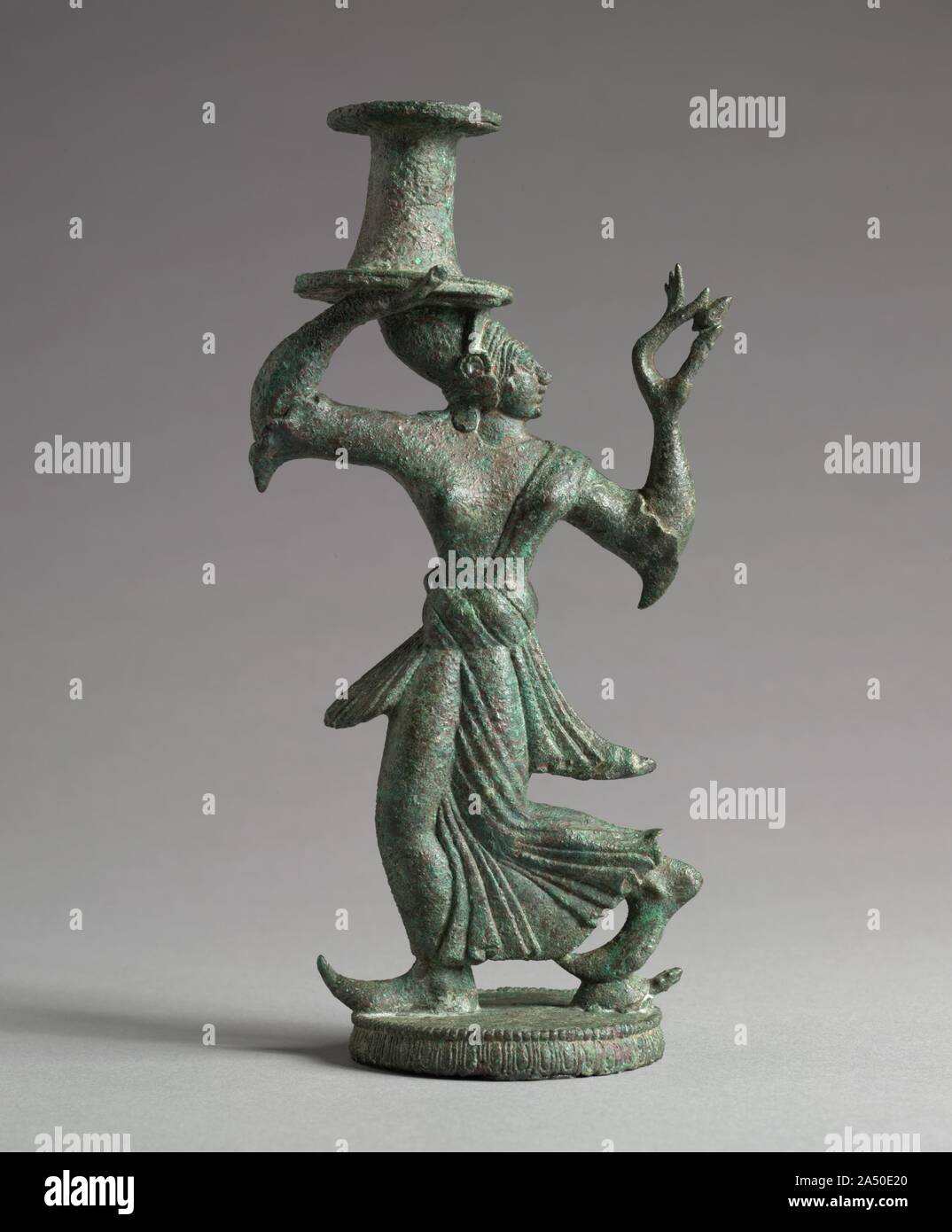 Candelabrum Stand of a Dancing Maenad, 525-500 BC. The woodland turtle beneath one of the maenad's feet identifies her. The work maenad means &quot;frenzied woman.&quot; and woman who followed the god of wine- Dionysus- performed their rites in the woods and mountains, with an ecstatic frenzy that earned them their name. Silhouette was of paramount importance to the early Etruscan artist. This elegant figure was conceived as separate front and back views, with virtually no side views. Its look is rather similar to the appearance of dancing figures painted on Greek vases, which were imported in Stock Photo