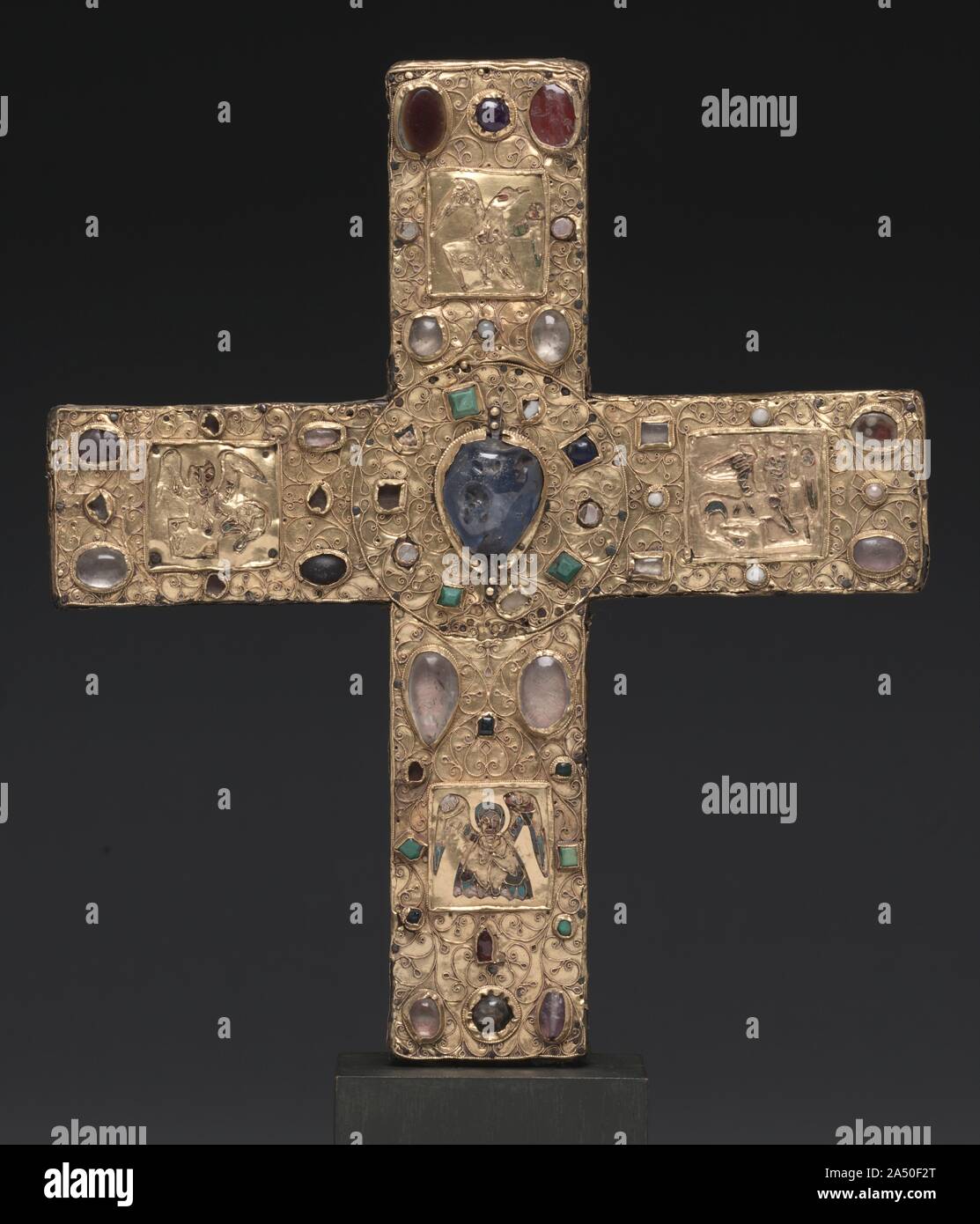 Ceremonial Cross of Countess Gertrude, 1038 or shortly after. This precious gold cross was commissioned by Countess Gertrude (died 1077) and given to the church of Saint Blaise following the death of her husband, Count Liudolf of Brunswick (died 1038). The cross was intended to be carried in liturgical processions or to be placed on a church altar. The inclusion of relics within the crosses endowed them with an additional role as devotional objects. At the center of the four cross arms, fine but much damaged cloisonn&#xe9; enamel plaques represent the symbols of the four Evangelists--an eagle Stock Photo