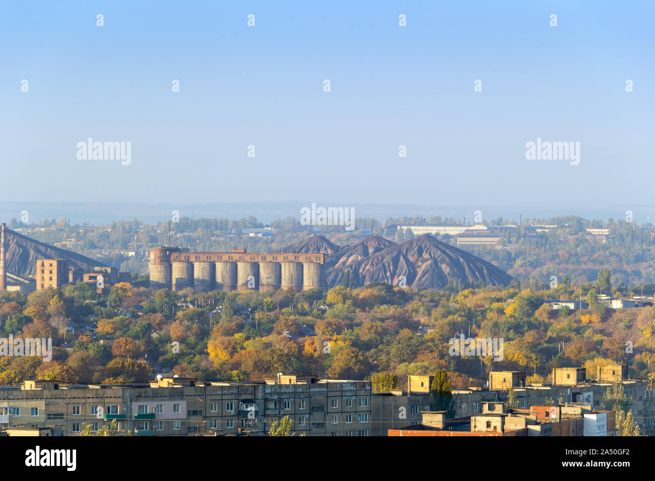 Industrial landscape. Coal processing plant in the Donetsk city. Scenic view of slag heap and constructions of factory over the roofs of residential Stock Photo