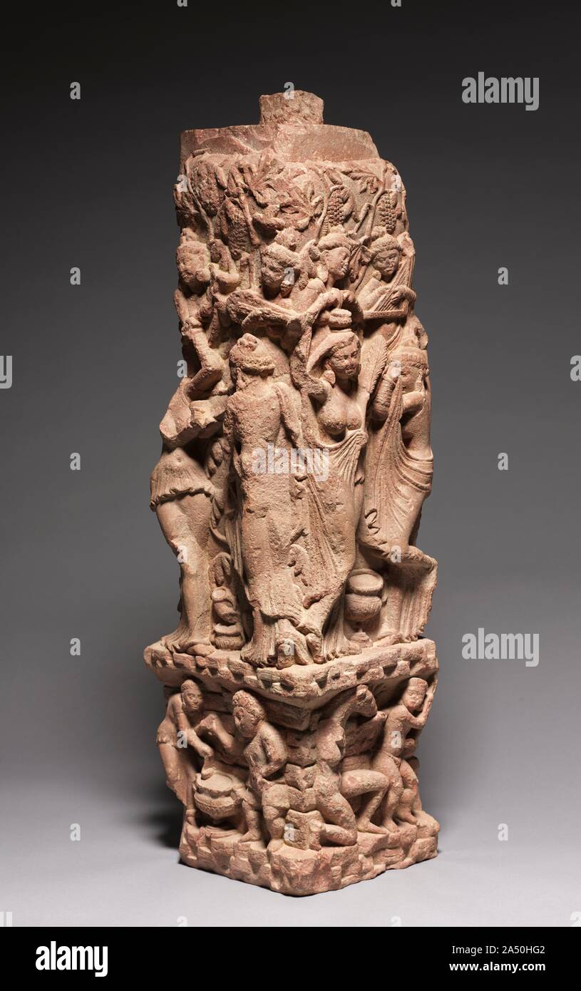 Corner Railing Pillar with Drinking Scenes, Yakshis, and Musicians, 100s. This upright post was positioned at the corner of a square railing or gateway surrounding a sacred site, demarcating it from the outside world. The carvings depict a bacchanale: grapevines heavy with fruit set the scene and musicians accompany the drinking and dancing. Below, a hunchbacked woman ladles wine into a cup for a dwarf in a rocky setting. On the other face, women, like the maenads of ancient Greece, struggle to keep their garments on, while below, a lustful horse-headed nature divinity, a  yakshi , accosts a y Stock Photo