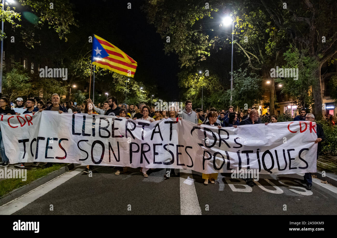 Protesters hold a banner and a flag while marching during the demonstration.Hundreds of protesters concentrated on the Gran Vía Street in Barcelona during the third day of protest following the sentences of the Spanish Supreme Court that condemns Catalan political prisoners to long prison terms. The demonstration culminated in front of the headquarters of the Department of Interior of the Generalitat with heavy police charges and barricades set on fire. Stock Photo