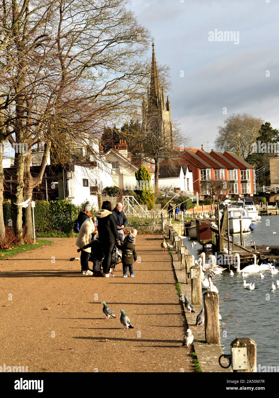 Waterside scene at Windsor Bridge with the Church of St John The Baptist, High Street, in the background Stock Photo