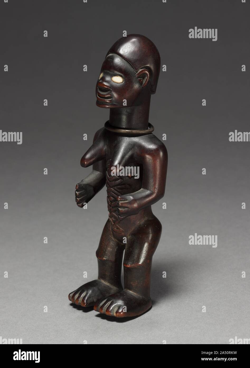 Female Figurine, late 1800s-early 1900s. Whether female or male, Beembe figurines generally have greatly detailed anatomical and decorative features&#x2014;especially hairstyles and abdominal scarification marks&#x2014;as well as a shiny, lustrous patina. The characteristic scars that were in vogue among Beembe men and women until the 1950s communicated their ideas about local beauty and ethnic belonging. Used to protect its owner&#x2019;s well-being, such a Beembe figurine was charged with an ancestor&#x2019;s spirit or life force through a mixture of resin and mostly human-derived ingredient Stock Photo