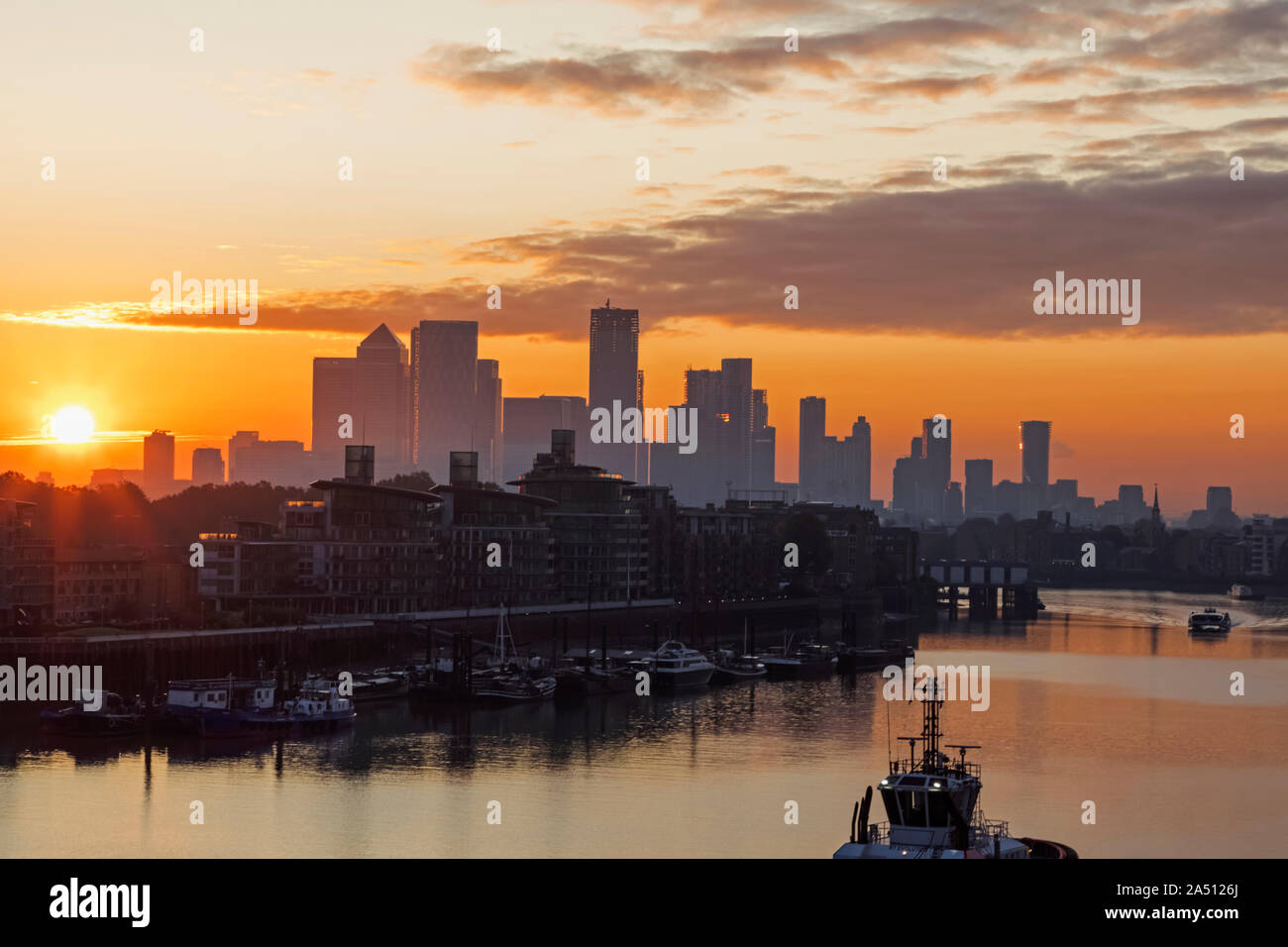 England, London, Docklands, Silouette of Canary Wharf Skyline and River Thames at Sunrise Stock Photo