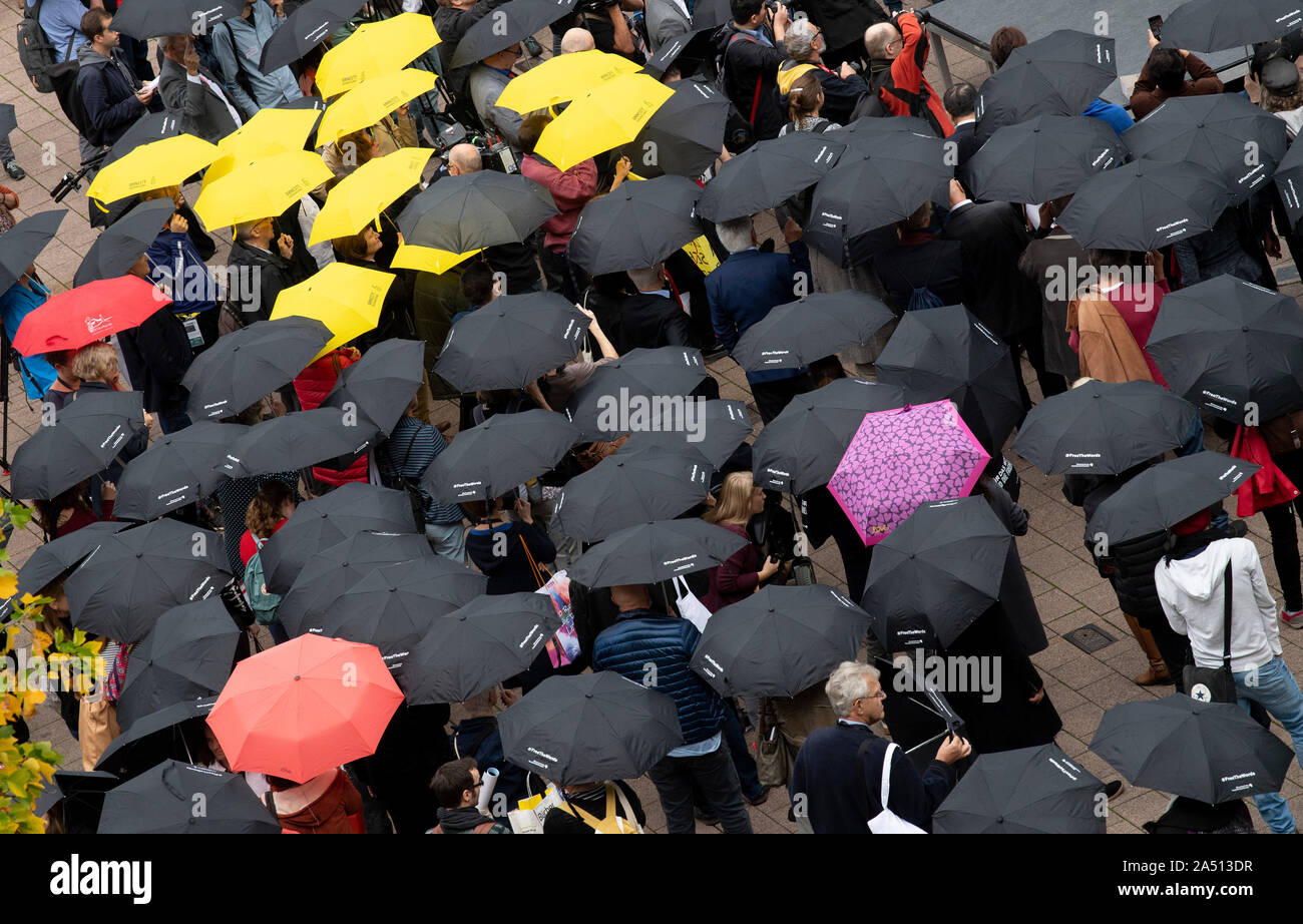 17 October 2019, Hessen, Frankfurt/Main: With umbrellas, numerous people at the Book Fair take part in a vigil for freedom of expression. This was primarily a sign of solidarity for the author Gui Minhai, who was imprisoned in China. Photo: Boris Roessler/dpa Stock Photo